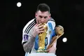Лионель Месси целует Кубок чемпиона мира по футболу. Лусаил (Катар). 2022