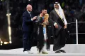 Капитан сборной Аргентины по футболу Лионель Месси, облачённый в традиционный арабский бишт, целует Кубок мира ФИФА. 2022