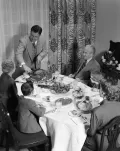 Американцы. Три поколения семьи за ужином на День благодарения. Отец семейства разрезает индейку. 1950-е гг.