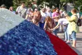 Россияне участвуют в создании государственного флага из бутонов роз во время празднования Дня России в Краснодаре. 2022