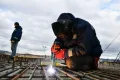 Рабочий со сварочным электродом на строительстве трассы «Таврида» в Бахчисарайском районе Крыма. 2020