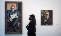 Посетительница выставки «Искусство общества 1900–1945» («The Art of Society 1900–1945») перед работами Макса Бекмана «Портрет Эрхарда Гепеля» (слева) и «Автопортрет в баре» (справа)